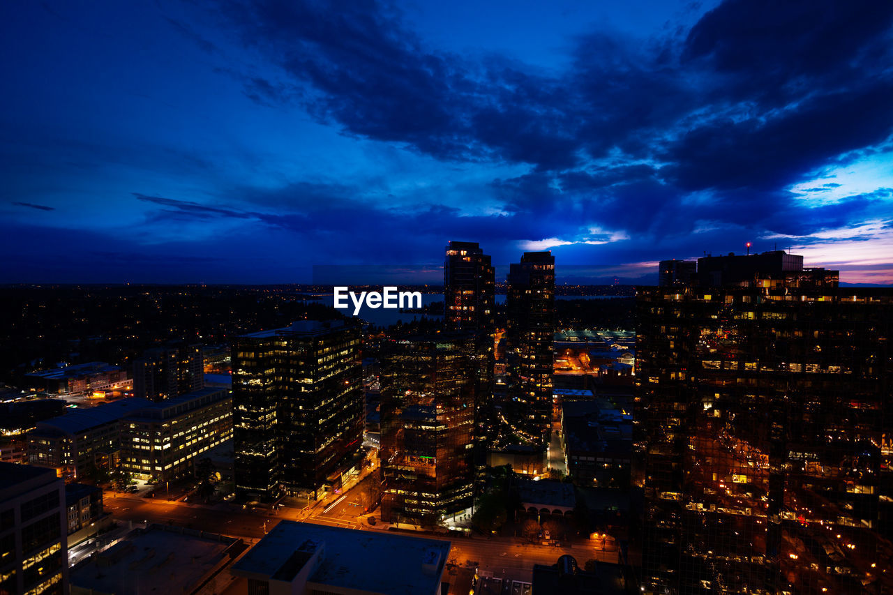 ILLUMINATED CITYSCAPE AGAINST SKY AT DUSK