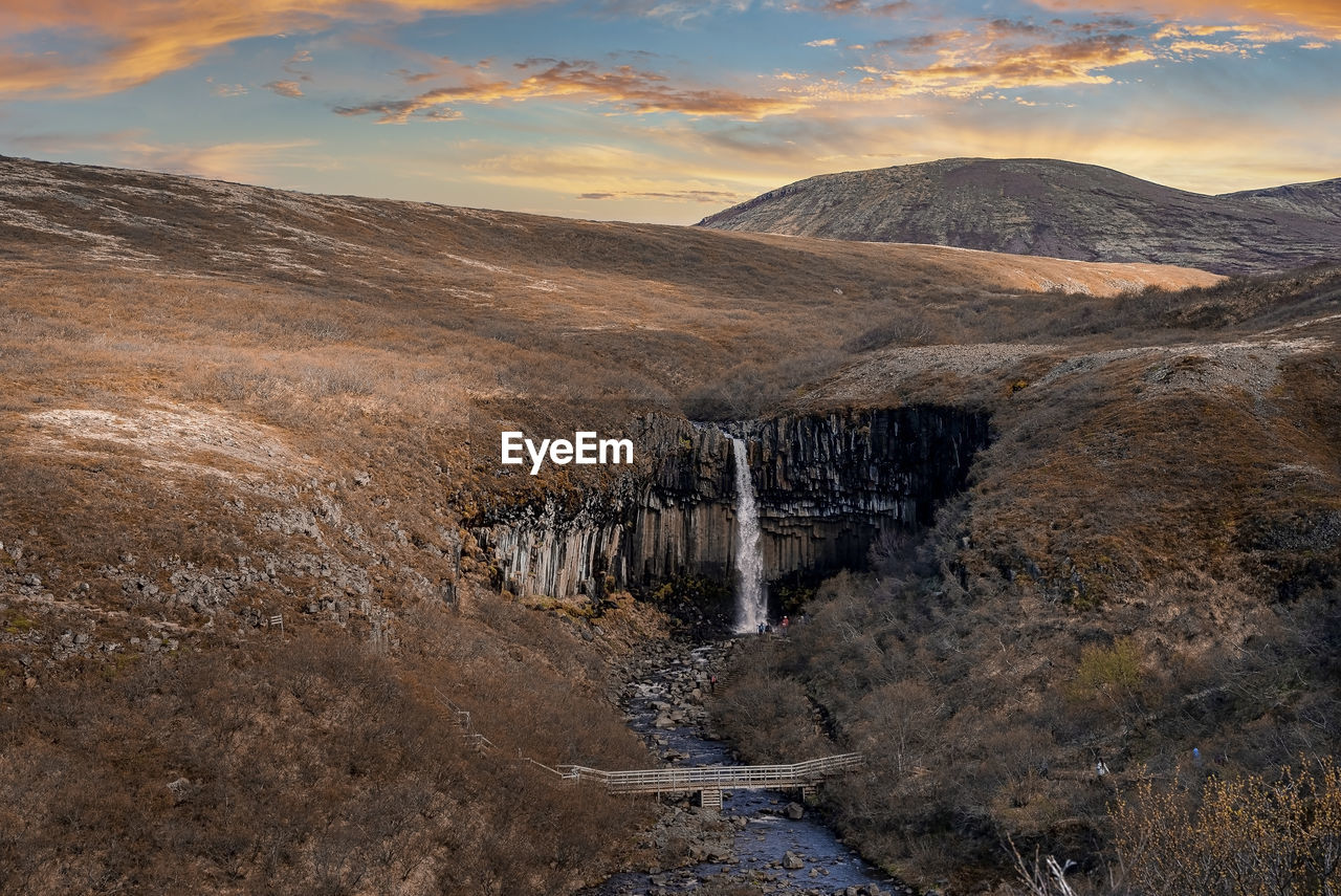 Aerial view of svartifoss waterfall surrounded by basalt columns during sunset