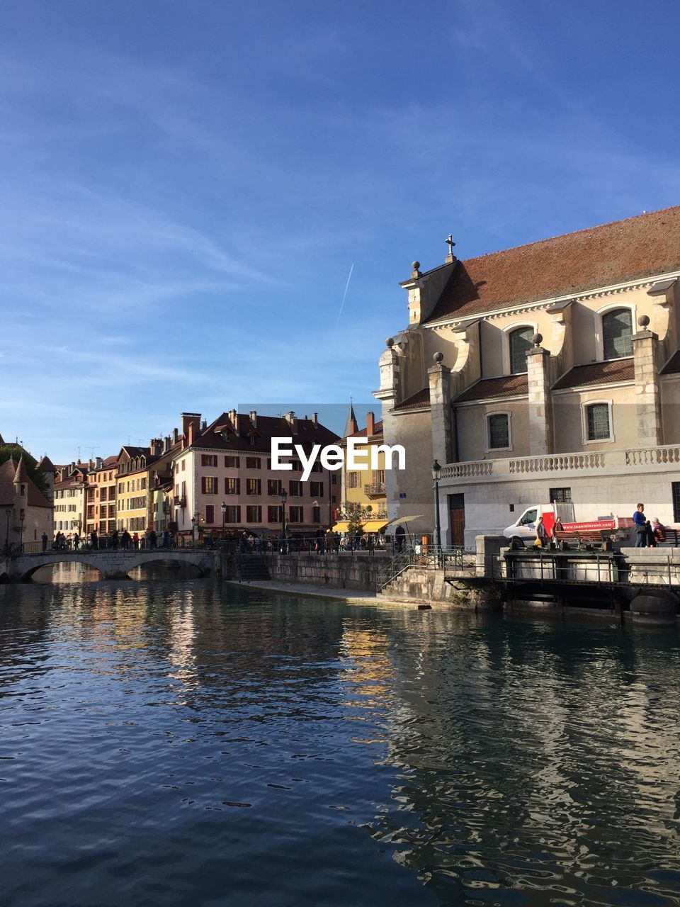 BUILDINGS BY RIVER AGAINST SKY IN TOWN