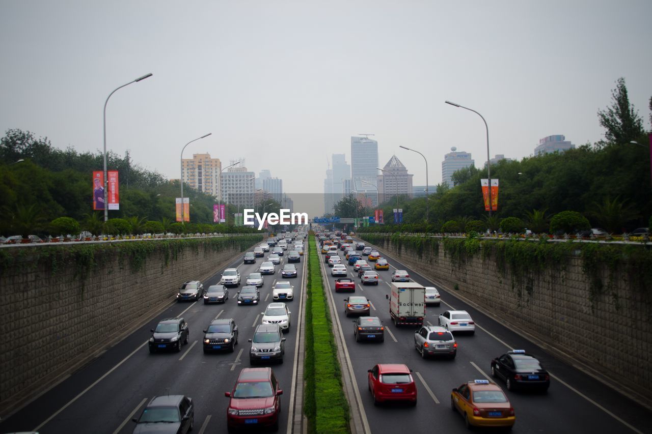 Traffic on road in city against sky