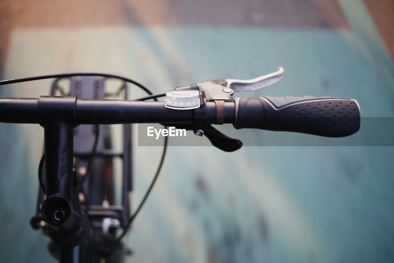 CLOSE-UP OF BICYCLE PARKED ON STREET AGAINST METAL