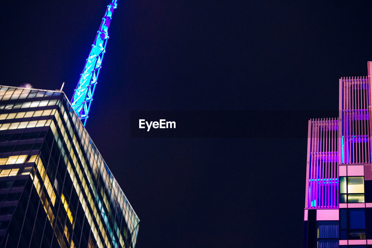 Low angle view of illuminated skyscraper against sky at night