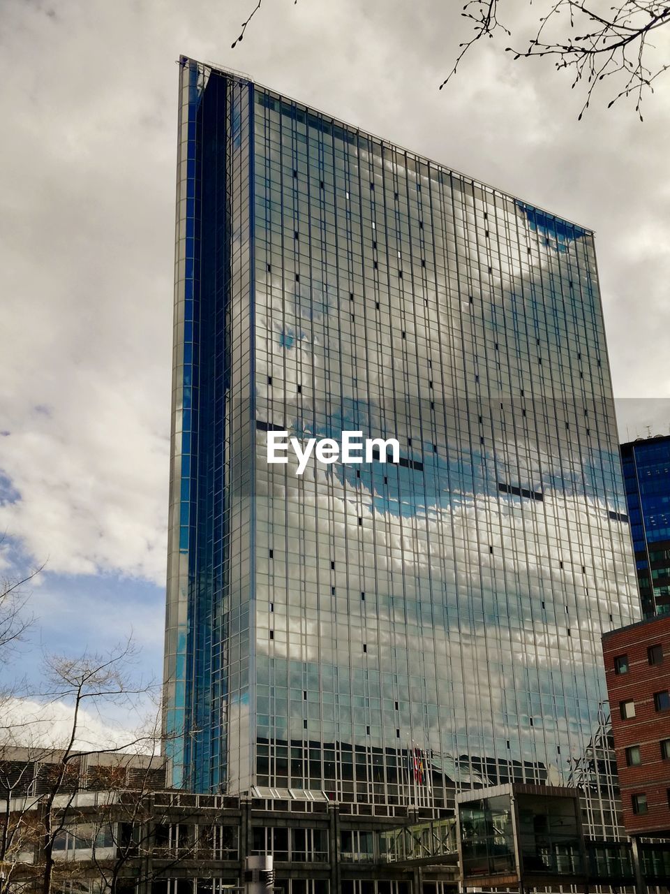 LOW ANGLE VIEW OF MODERN BUILDING AGAINST SKY IN CITY