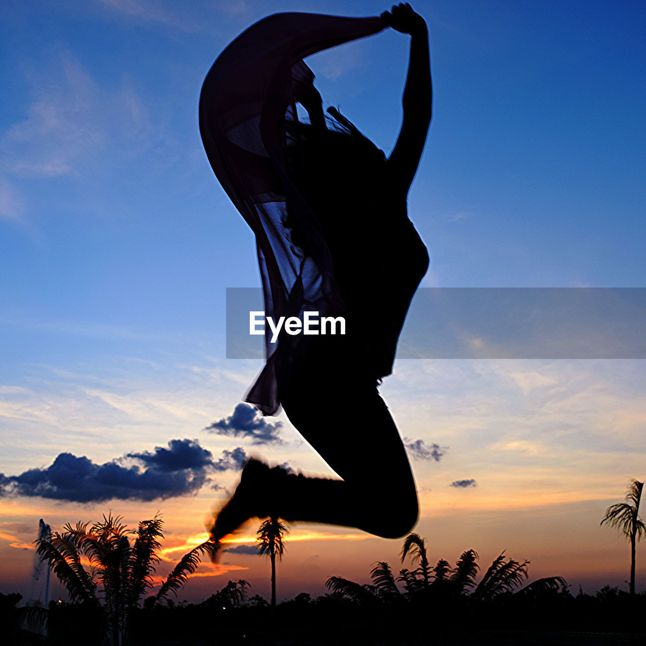 Silhouette woman jumping against sky during sunset