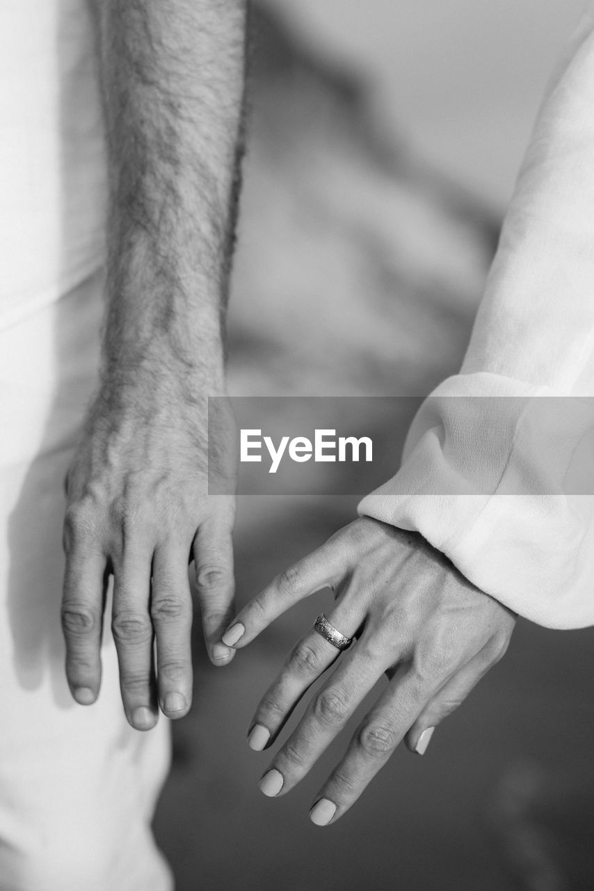 CLOSE-UP OF COUPLE HANDS WITH BABY