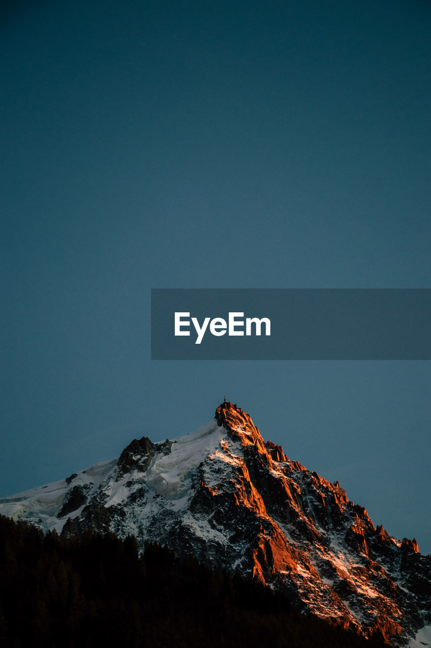 Low angle view of mountain against clear blue sky