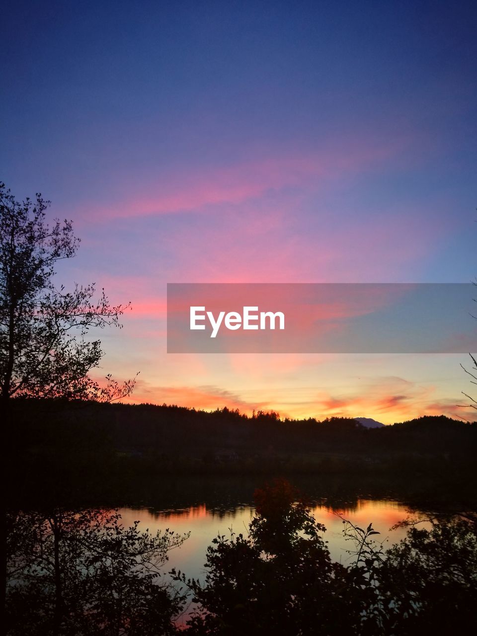 SCENIC VIEW OF LAKE AGAINST ORANGE SKY