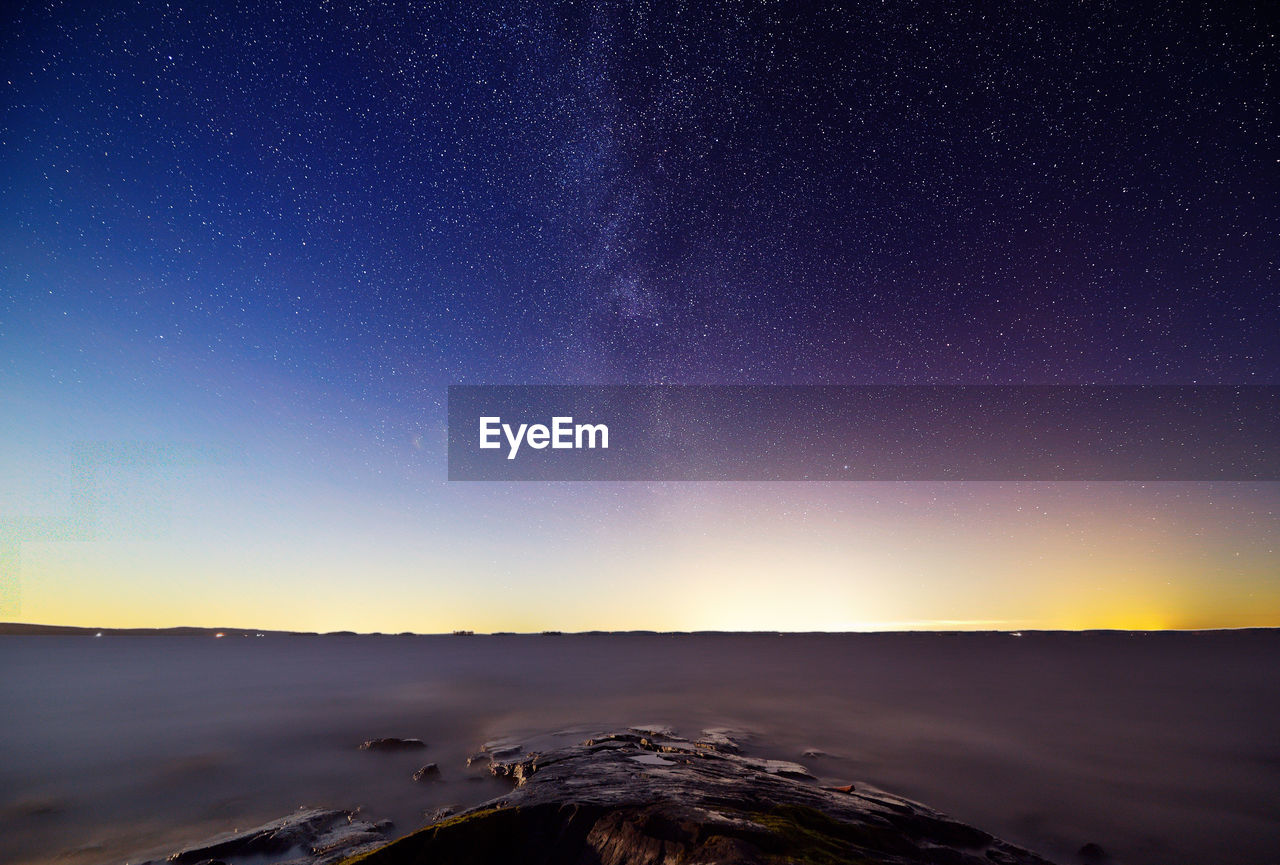 Scenic view of snowcapped mountains against sky at night