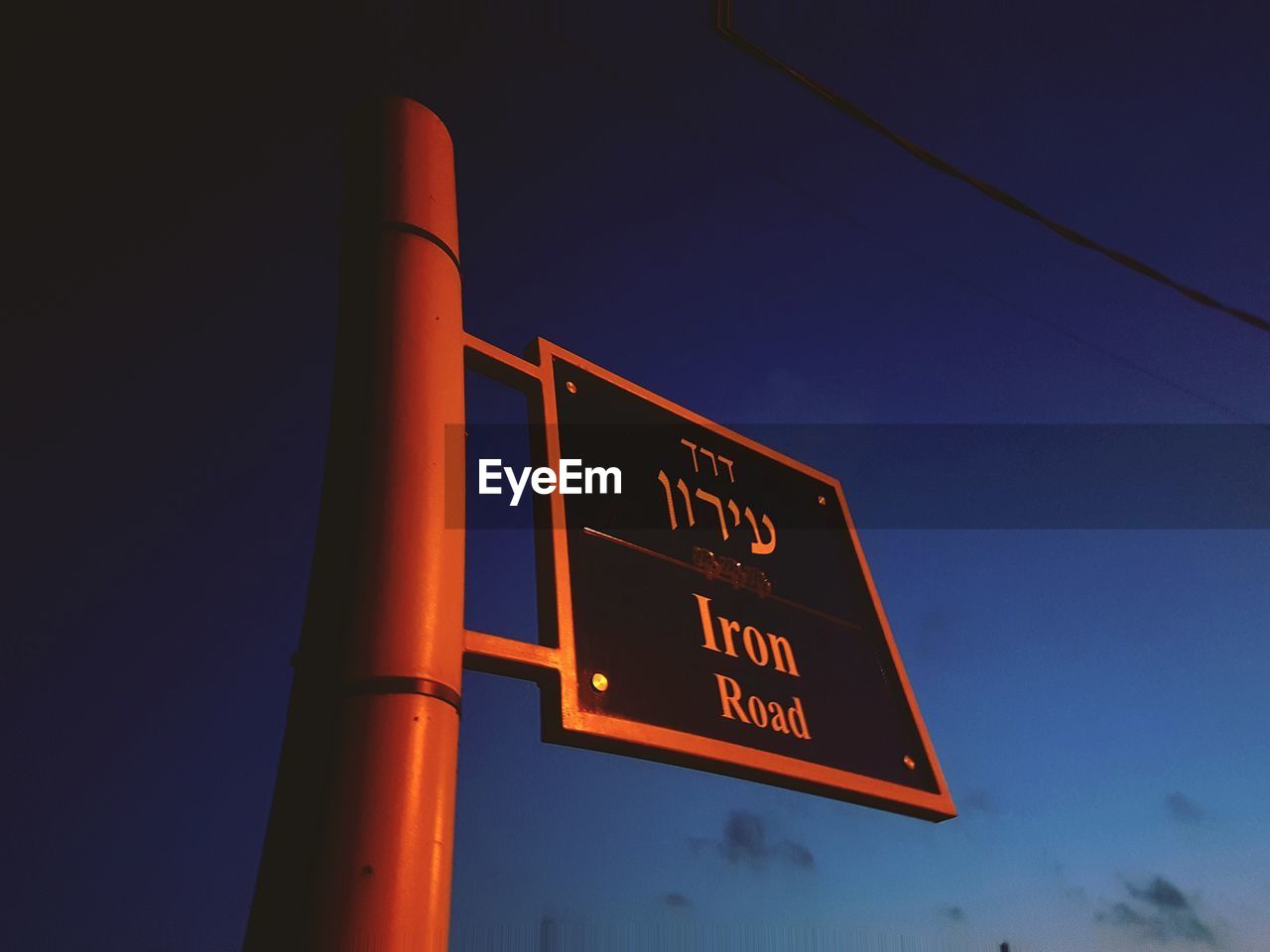 LOW ANGLE VIEW OF ILLUMINATED INFORMATION SIGN AGAINST SKY