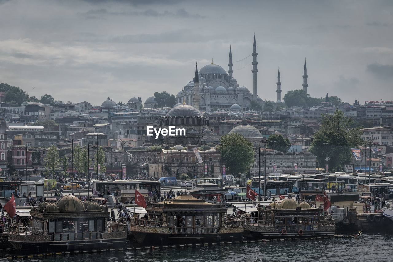 High angle view of cityscape against cloudy sky during sunny day