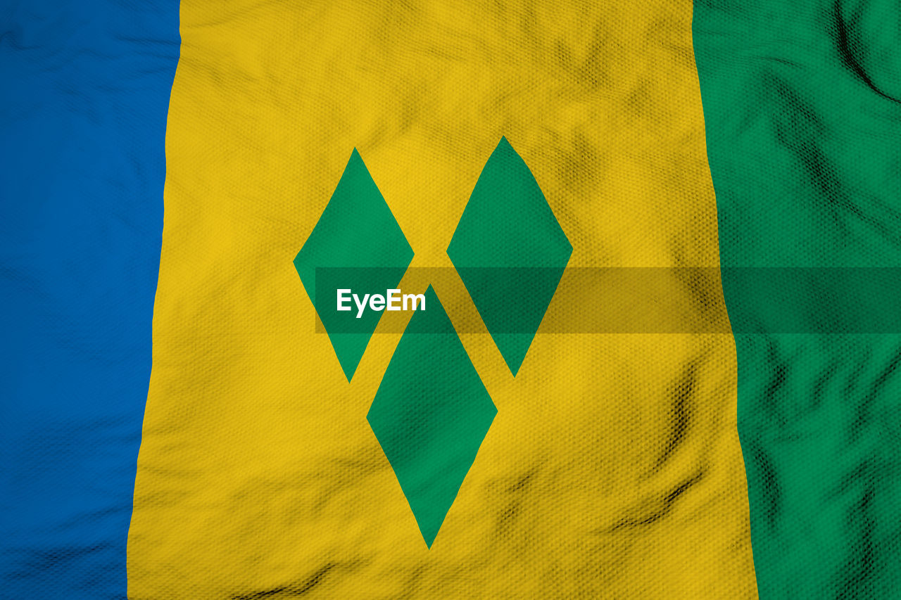 Full frame close-up on a waving flag of saint vincent and the grenadines in 3d rendering.