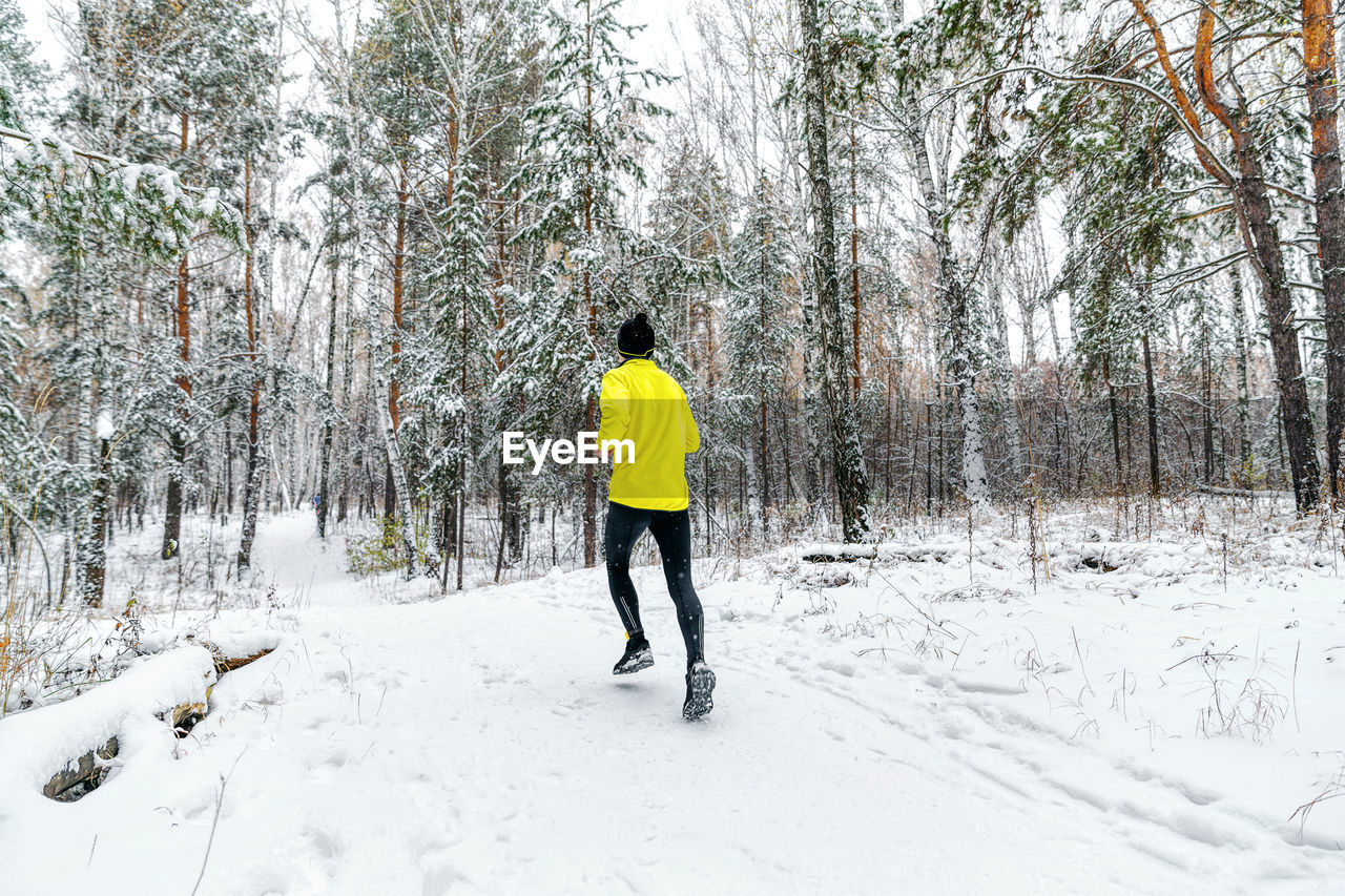 Back male runner run winter forest trail race