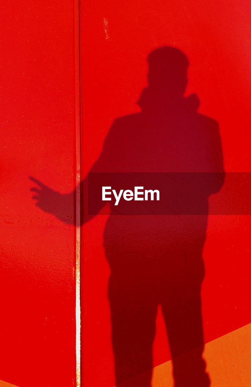 Shadow of person on red wall