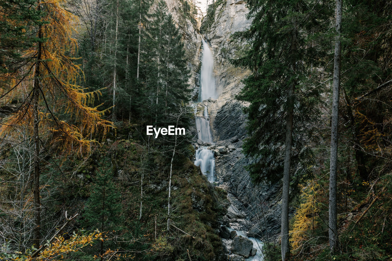 Beautiful waterfall in moody forest in autumn in gozd martuljek in slovenia