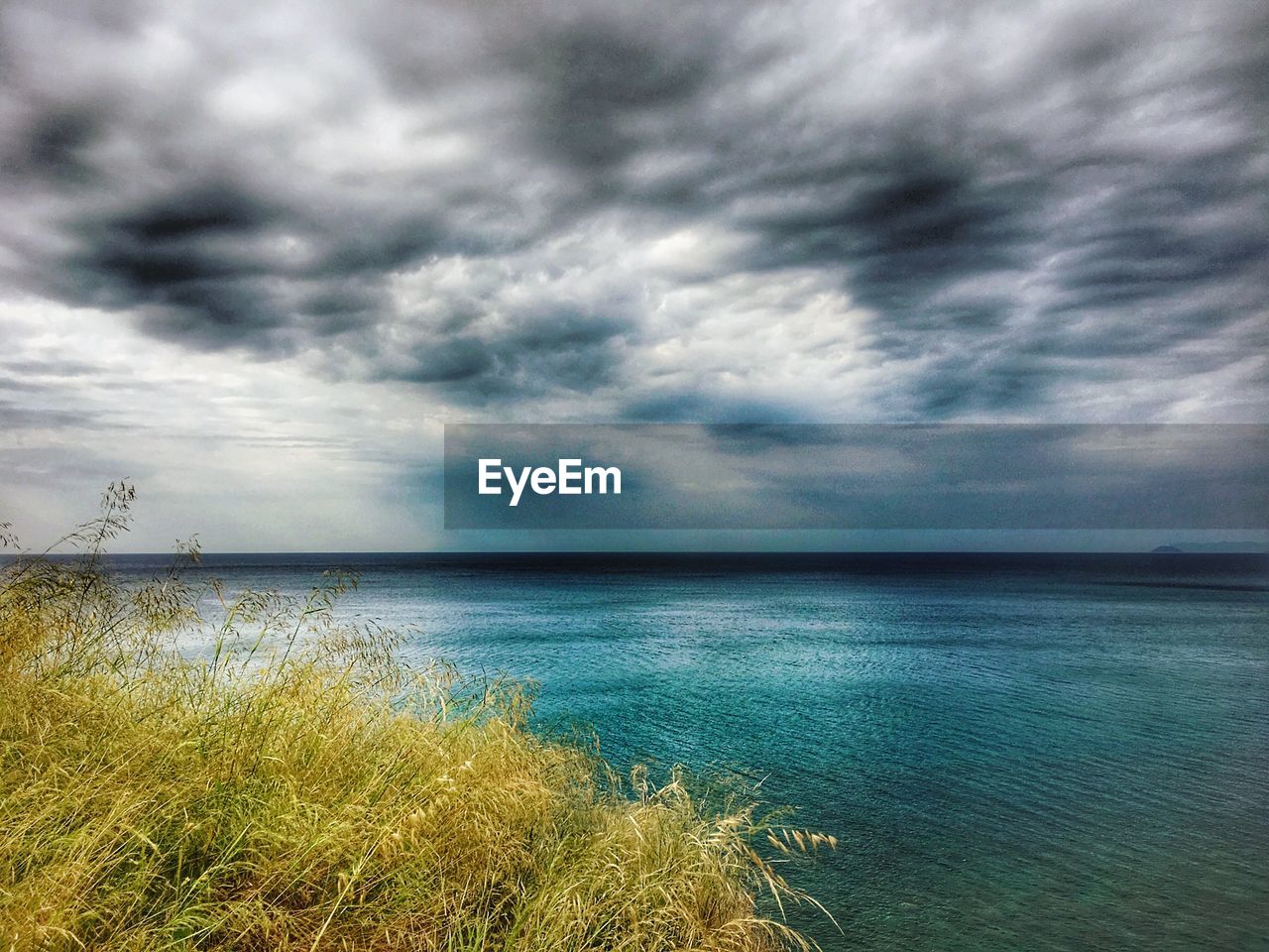 VIEW OF SEA AGAINST CLOUDY SKY