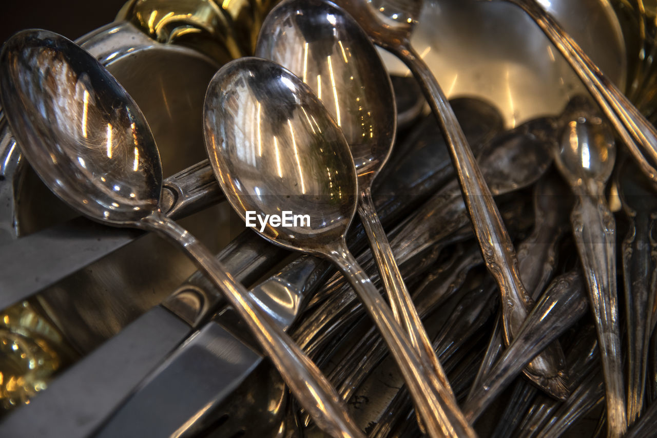 High angle view of steel spoons and forks 