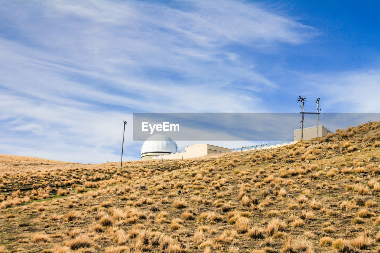 WIND TURBINES ON LAND AGAINST SKY