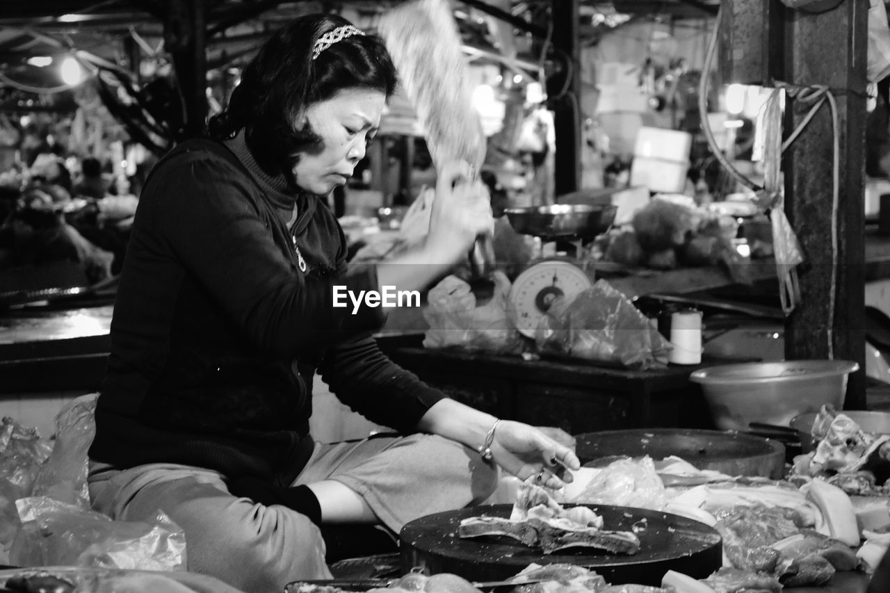 MAN PREPARING FOOD IN MARKET