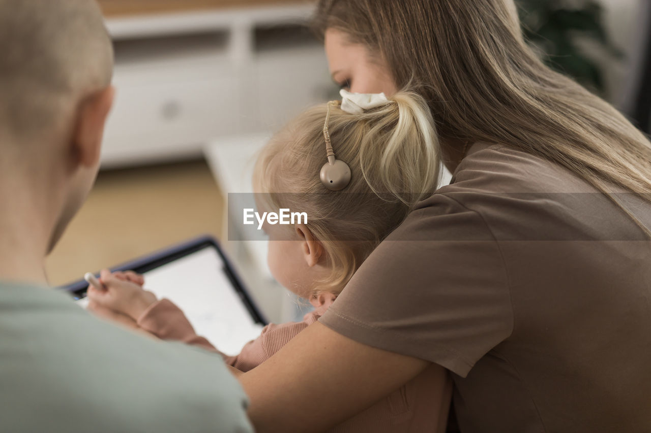 side view of woman using digital tablet while sitting at home