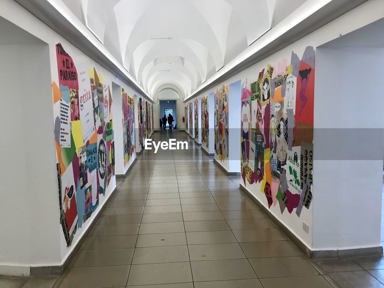 REAR VIEW OF MAN WALKING IN CORRIDOR