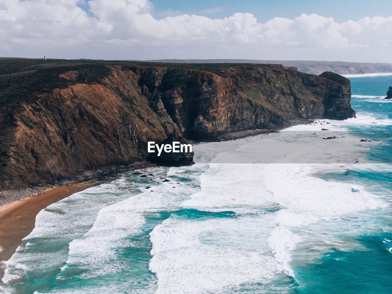 SCENIC VIEW OF ROCKY SHORE BY SEA AGAINST SKY