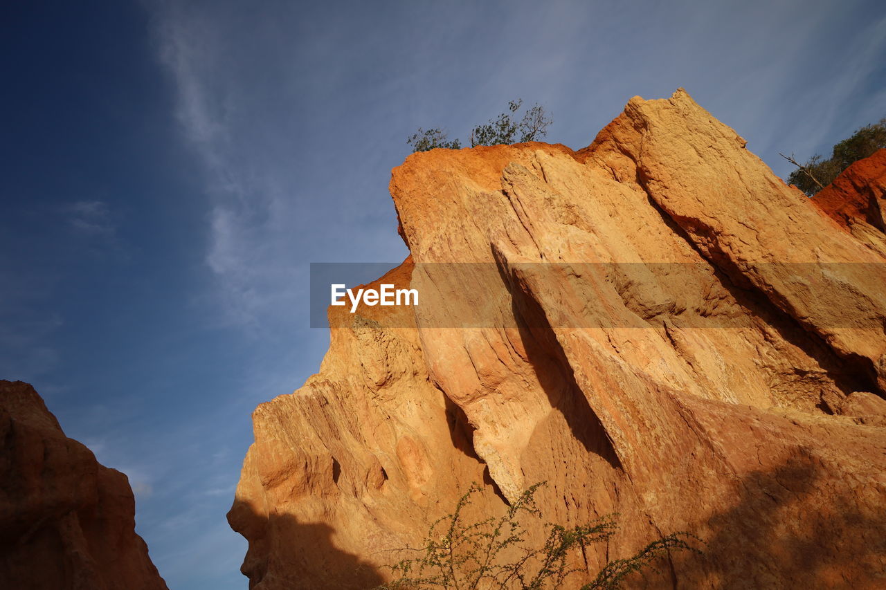 rock, sky, rock formation, nature, scenics - nature, landscape, beauty in nature, environment, cloud, travel destinations, land, mountain, travel, non-urban scene, geology, desert, terrain, no people, cliff, outdoors, extreme terrain, tranquility, physical geography, valley, formation, climate, sunlight, arch, eroded, mountain range, day, tourism, semi-arid, tranquil scene, low angle view, sandstone, wadi, blue, remote, plateau