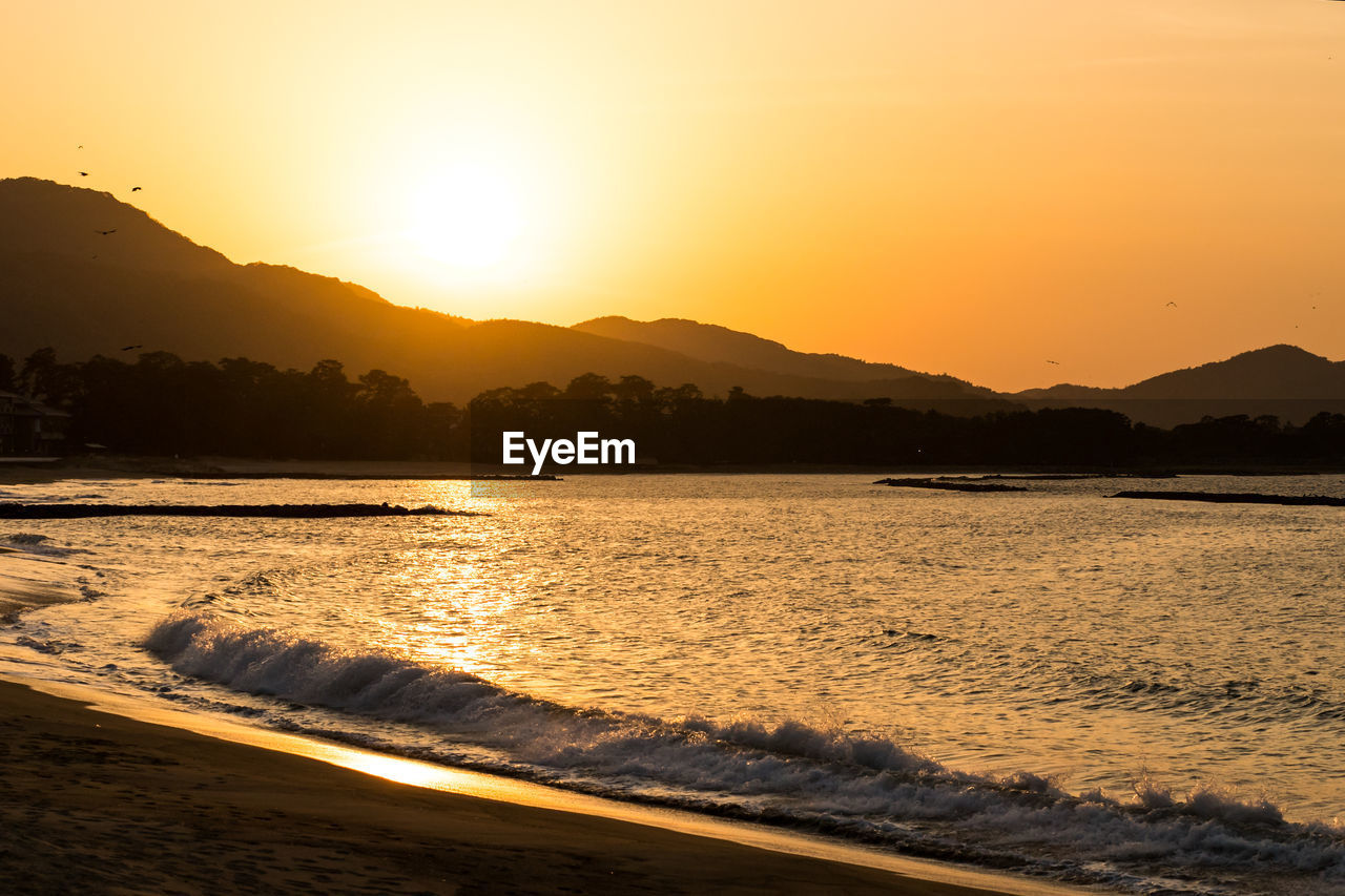 SCENIC VIEW OF SUNSET OVER SEA