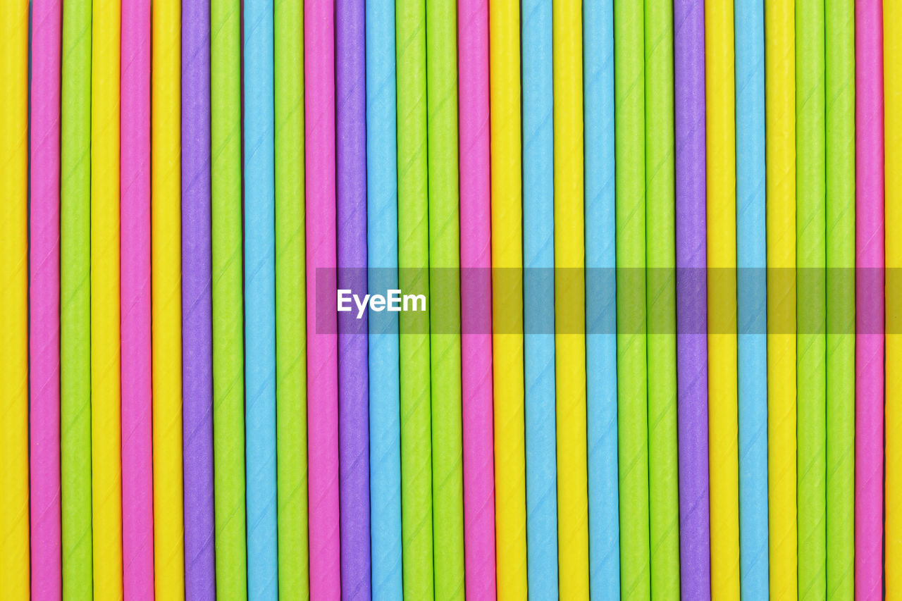 Colored paper straw pattern background. flat lay cocktail tube abstract vertical line texture