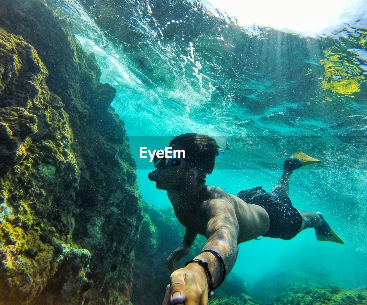 Rear view of man swimming underwater