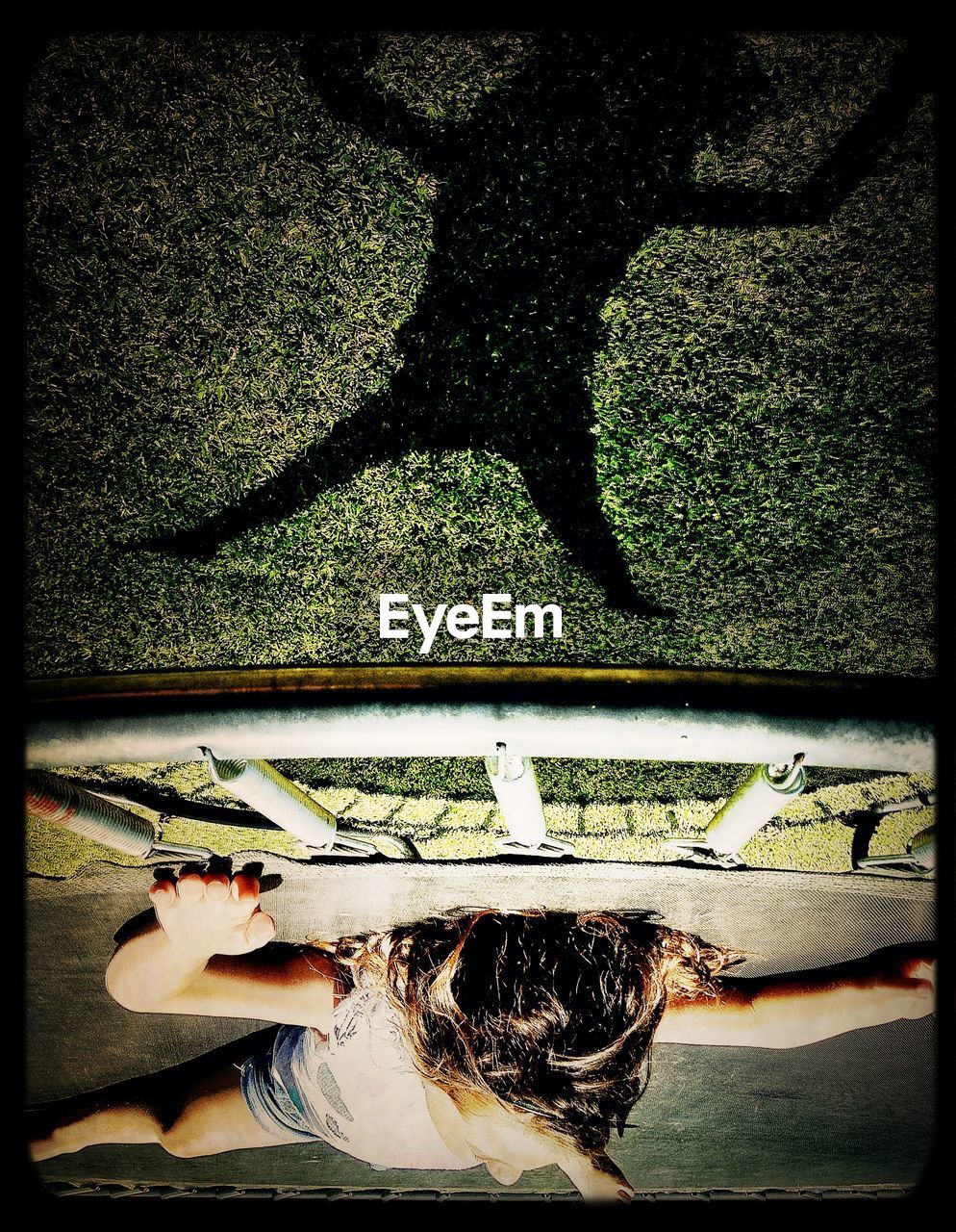 Young girl relaxing on trampoline in yard