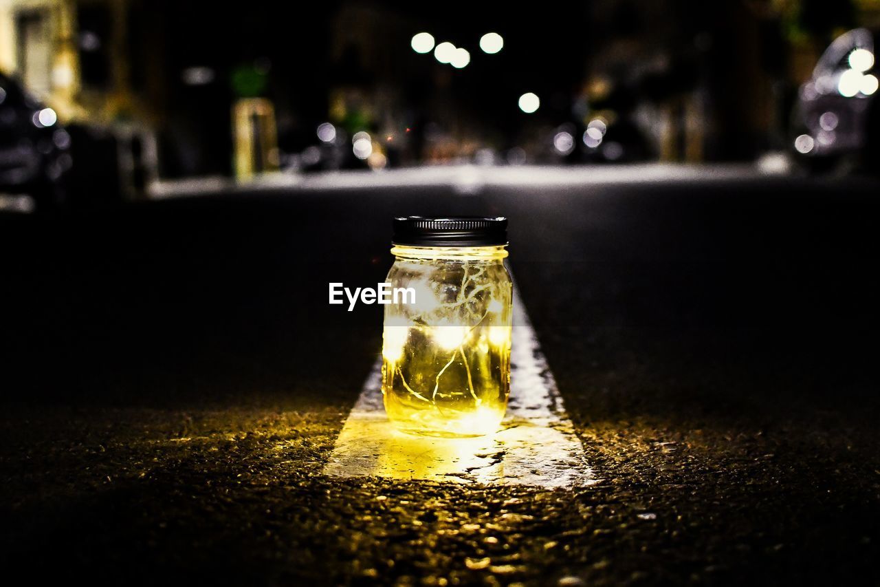 CLOSE-UP OF GLASS BOTTLE ON TABLE