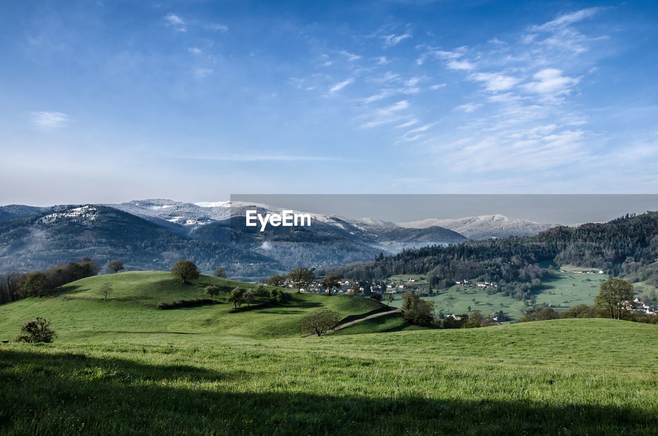 SCENIC VIEW OF FIELD AND MOUNTAINS AGAINST SKY