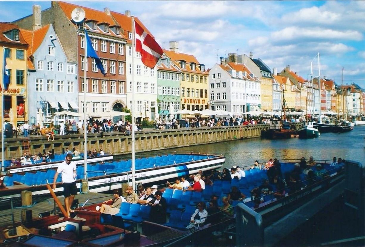 BOATS IN RIVER WITH CITY IN BACKGROUND