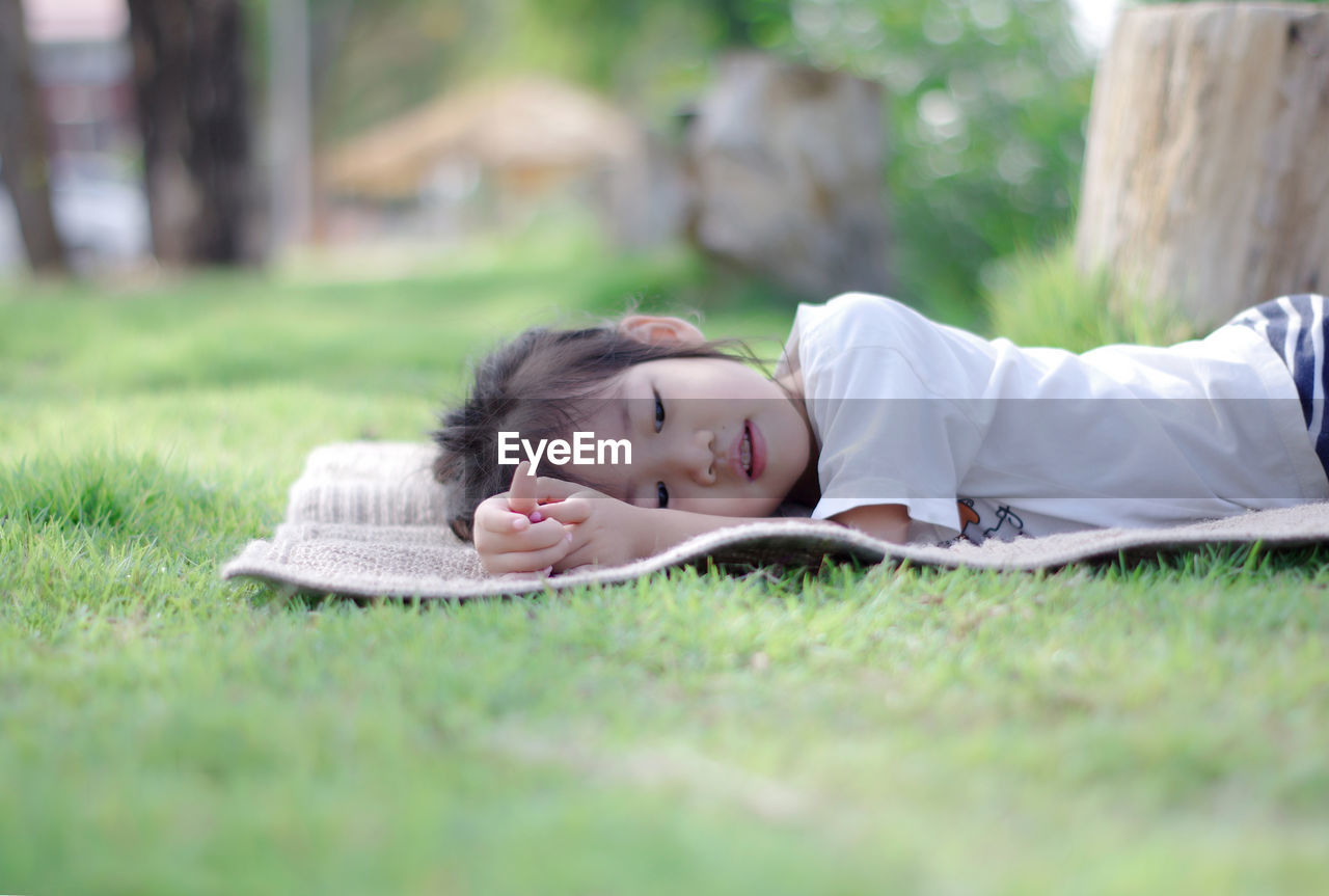 Cute girl lying on picnic blanket at park