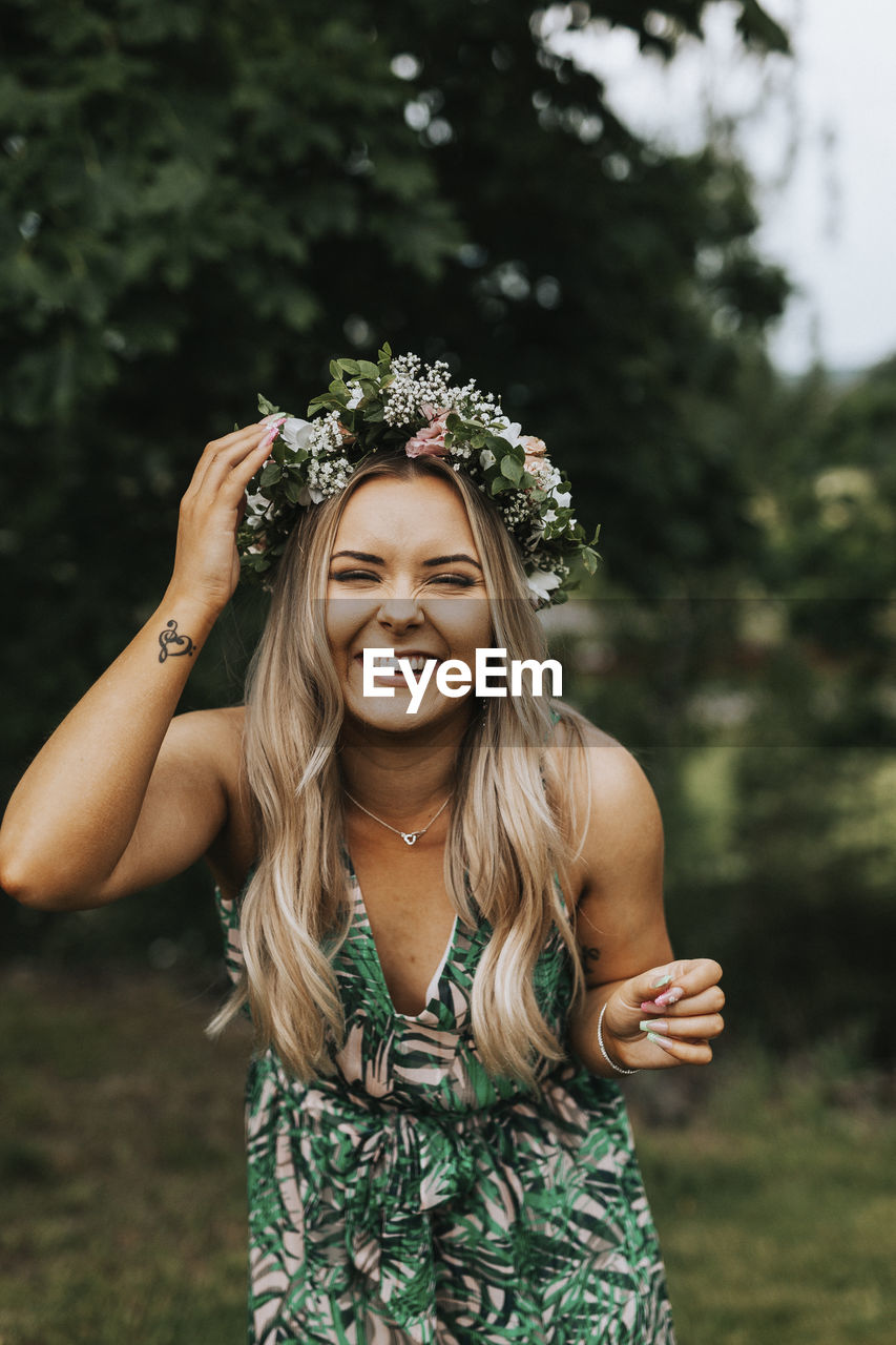 Happy woman wearing wreath of flowers