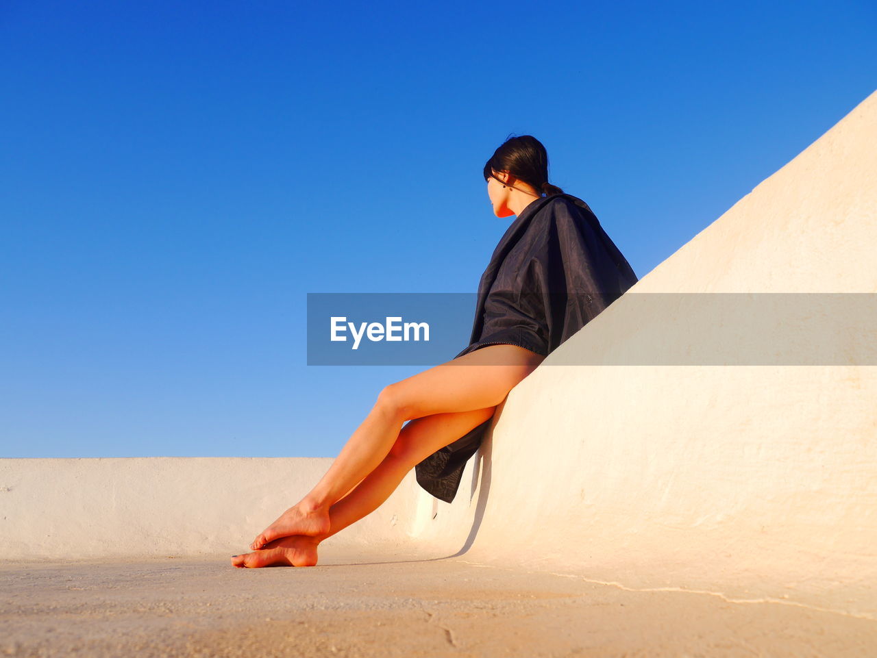 WOMAN STANDING AGAINST CLEAR SKY