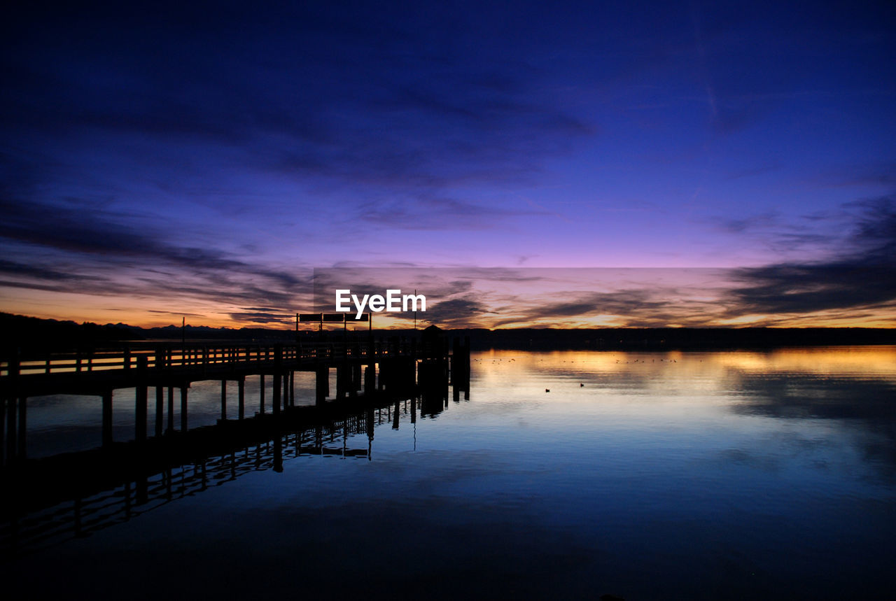 Pier over sea against sky during sunset