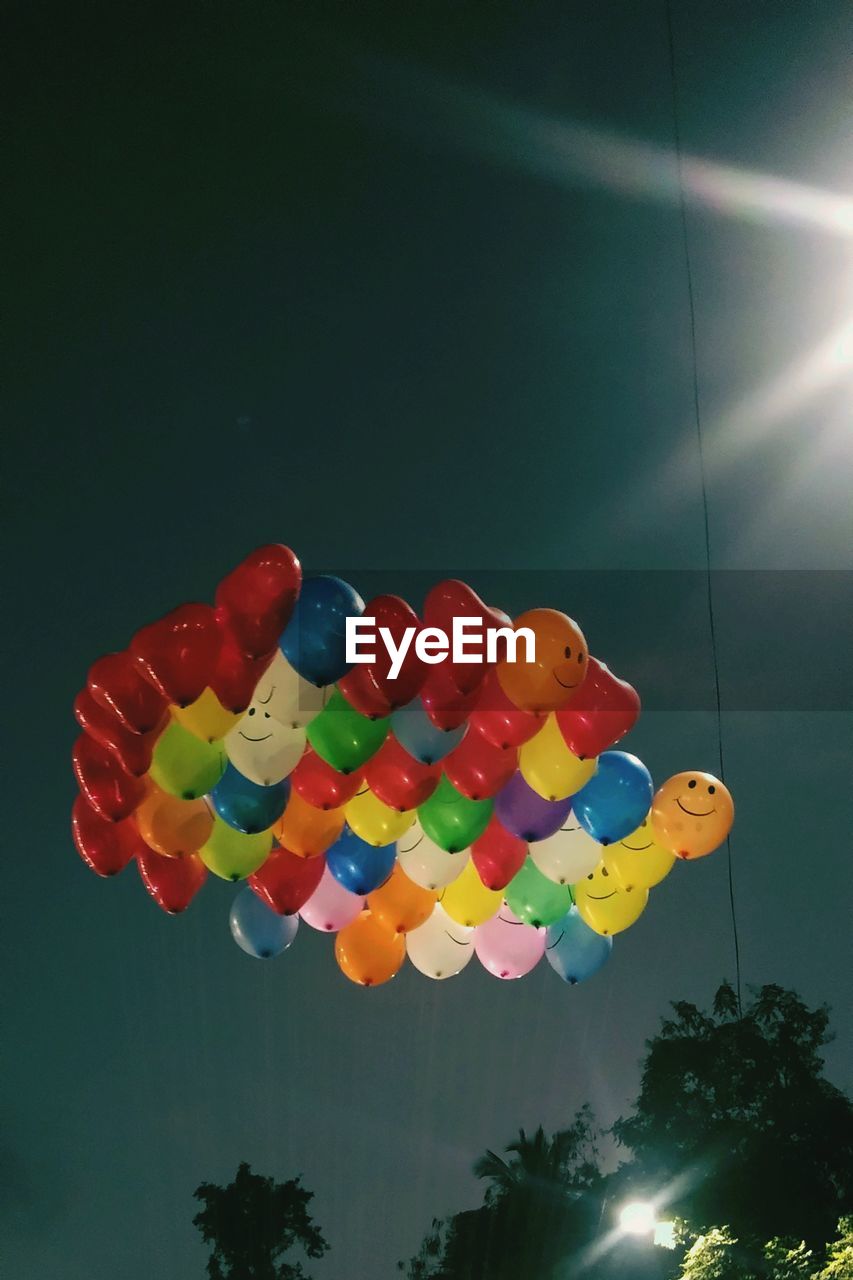 LOW ANGLE VIEW OF BALLOONS AGAINST SKY AT NIGHT