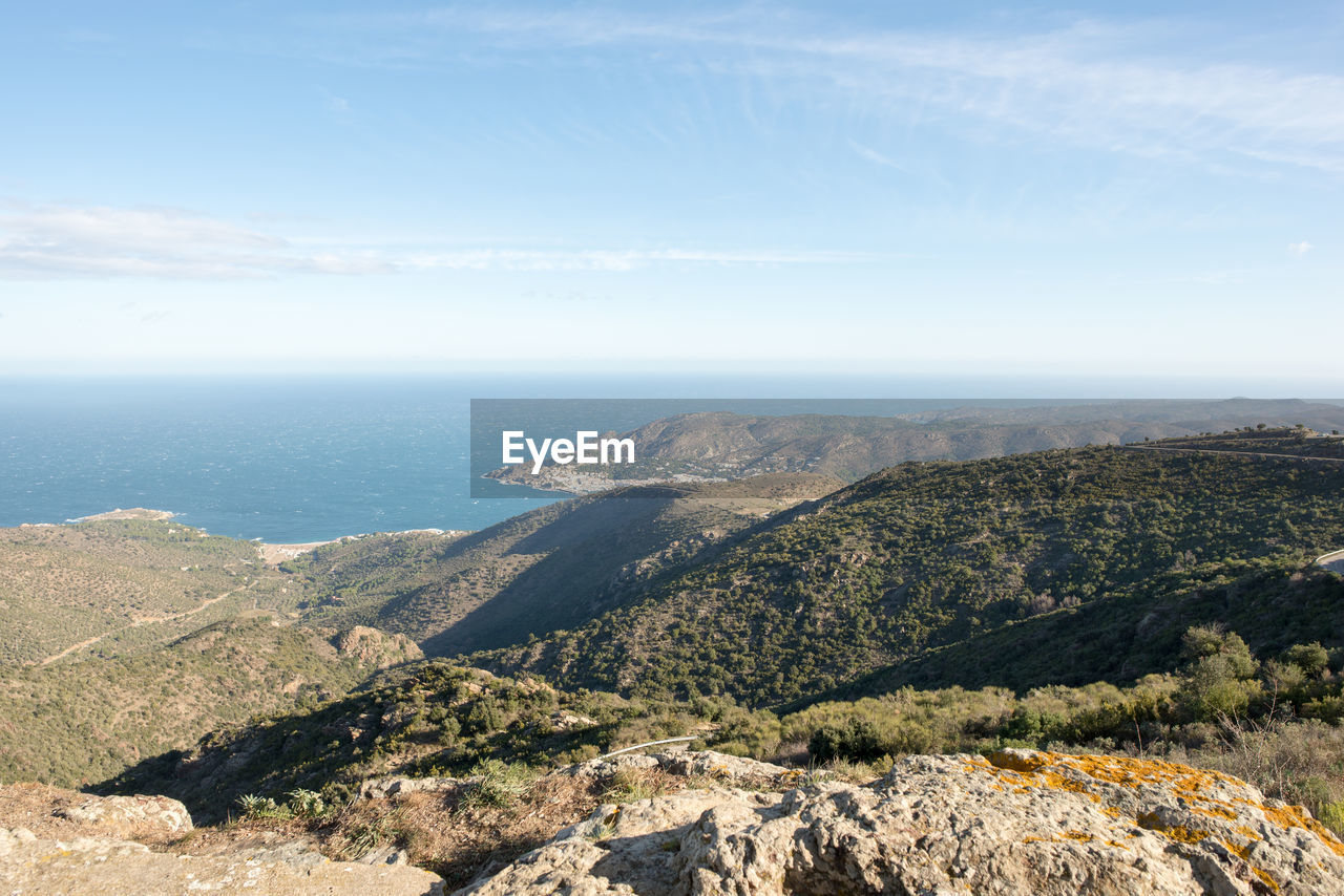 Scenic view of sea and mountains against sky