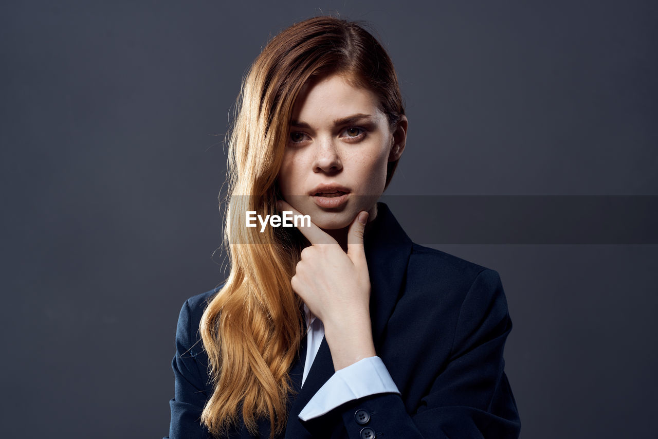 Portrait of a beautiful young woman over black background