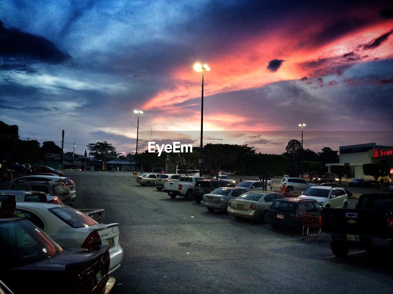 Cars on road against sky during sunset