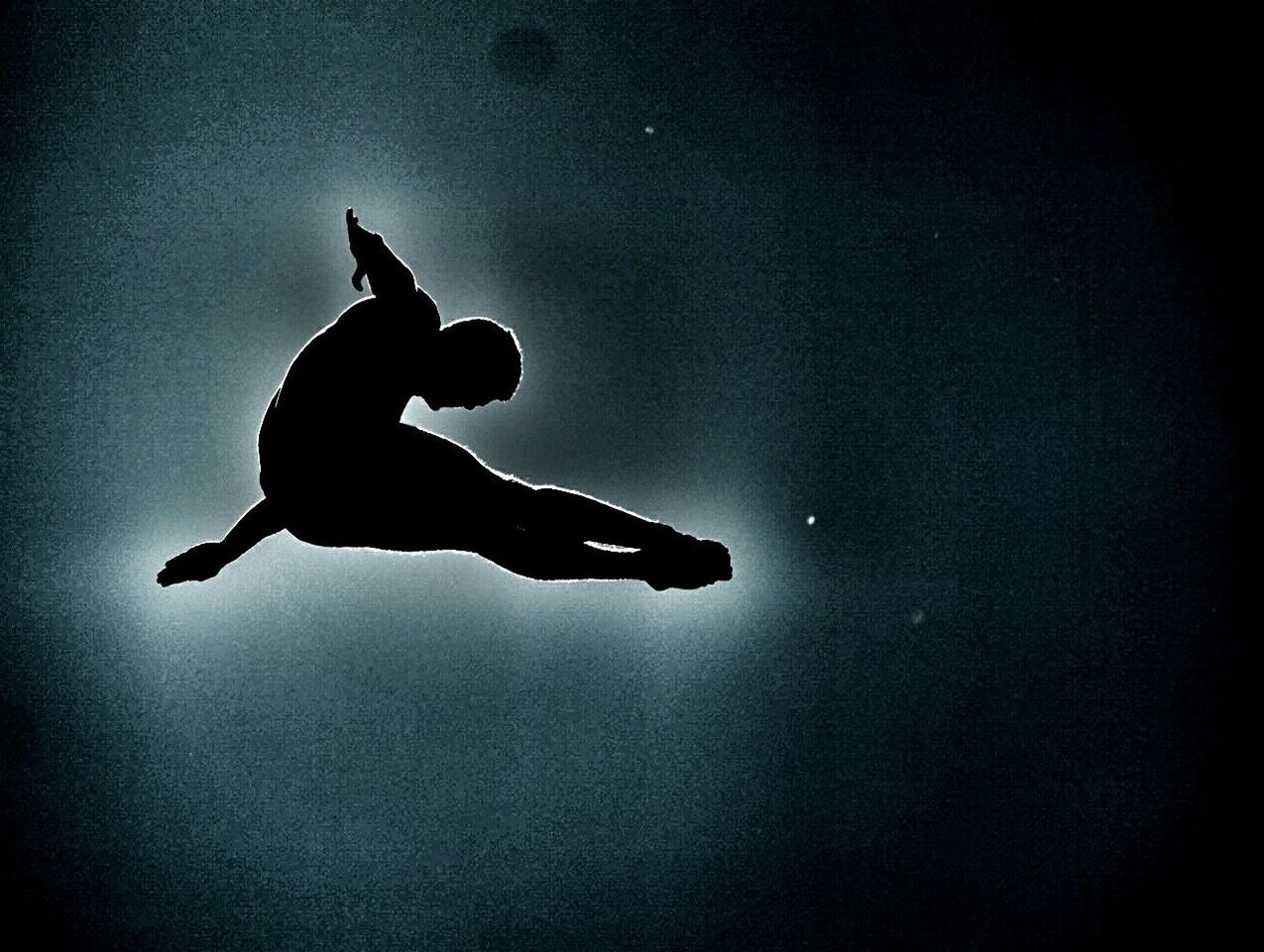 Low angle view of silhouette man jumping against sky