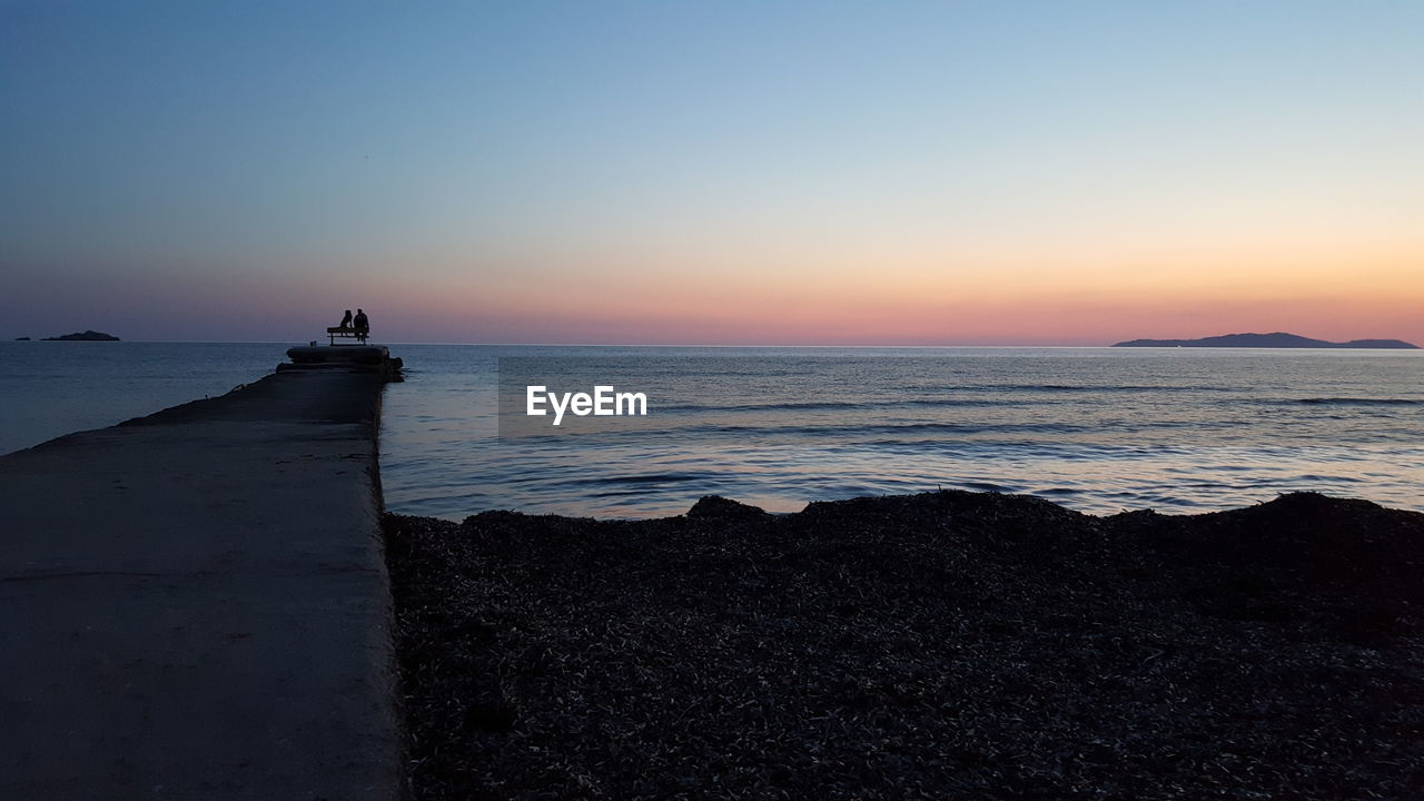 SCENIC VIEW OF SEA AGAINST SKY AT SUNSET