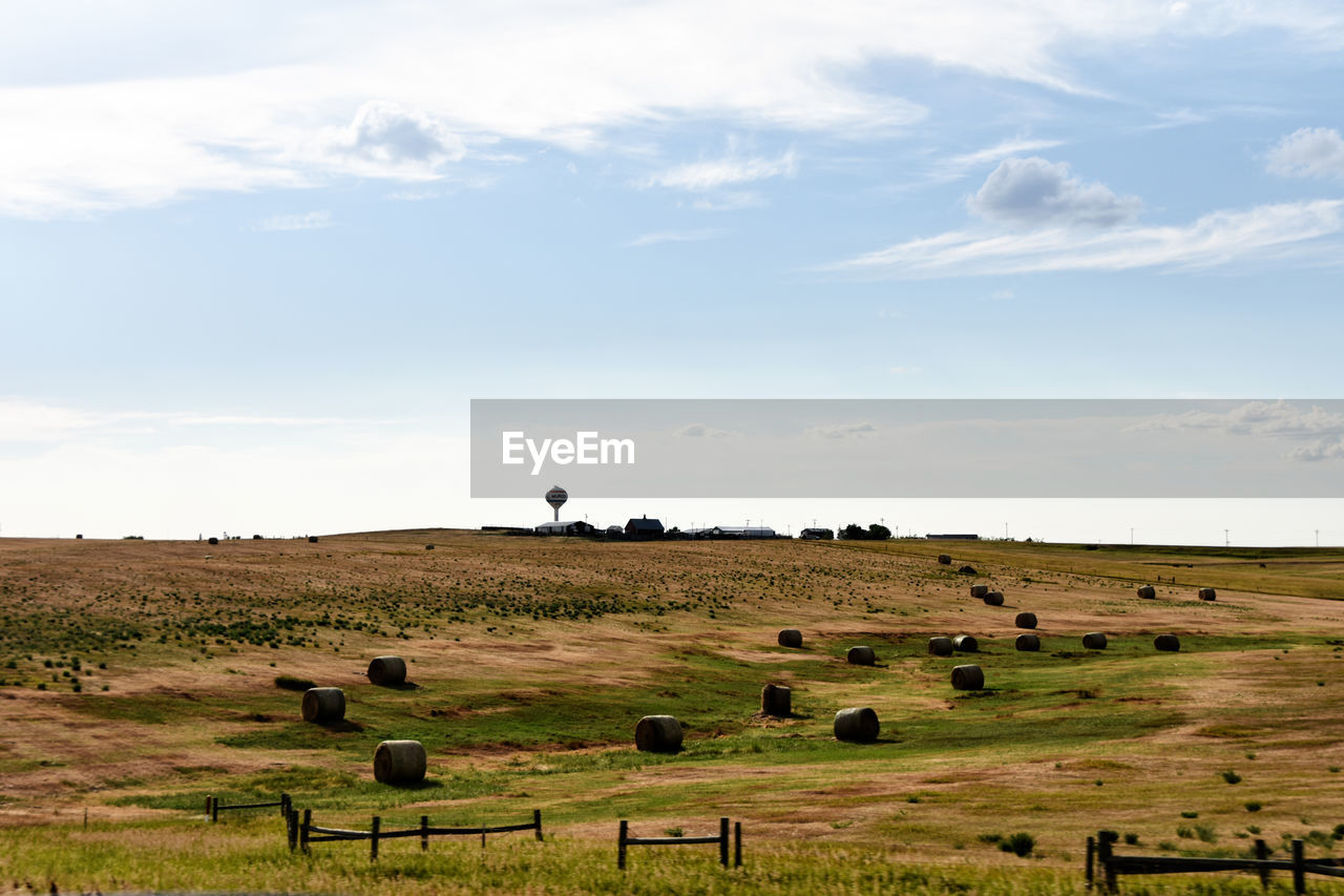 SCENIC VIEW OF HAY BALES ON FIELD AGAINST SKY