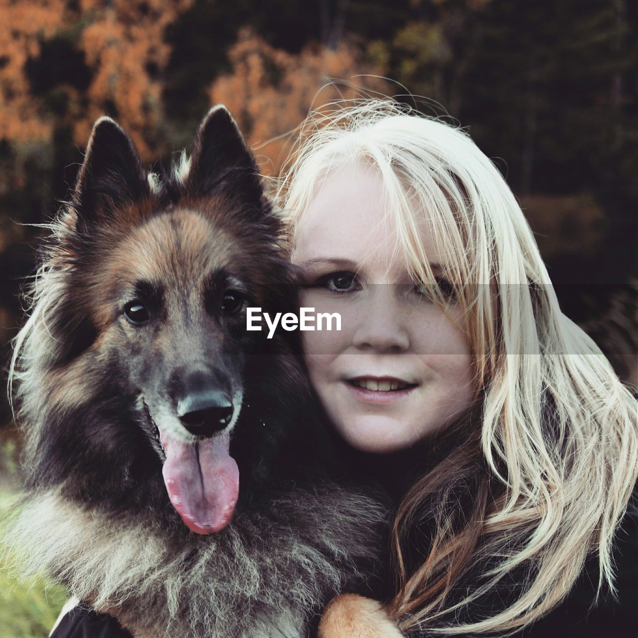 Close-up portrait of young woman with german shepherd