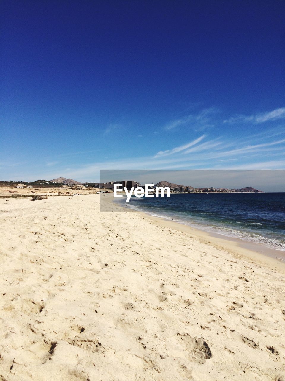 Scenic view of beach against blue sky