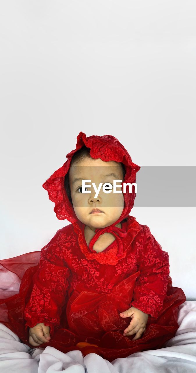 red, childhood, baby, child, portrait, one person, cute, celebration, pink, toddler, indoors, clothing, looking at camera, doll, toy, emotion, sitting, winter, studio shot, front view, innocence, christmas, holiday, white background, person, costume, smiling, copy space, nature, happiness