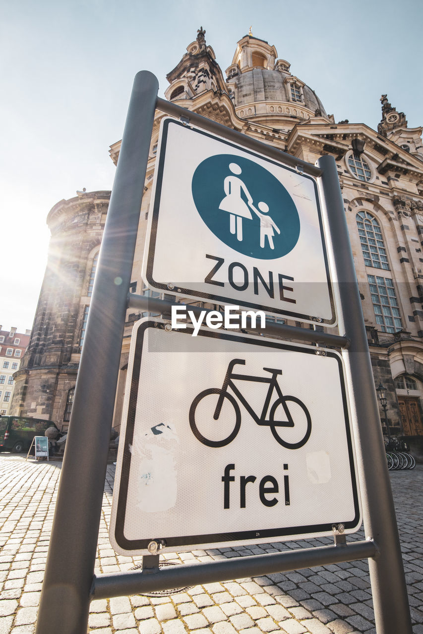 Low angle view of road sign against building in city