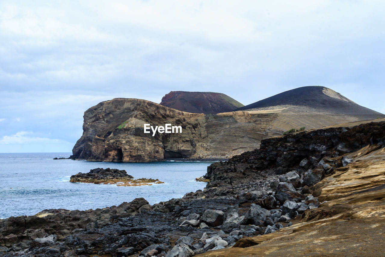 Rock formations by sea against sky