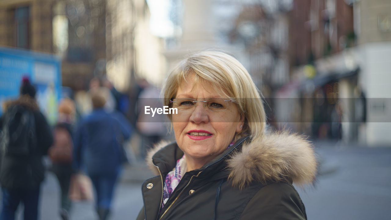 Portrait of senior woman wearing jacket on street in city